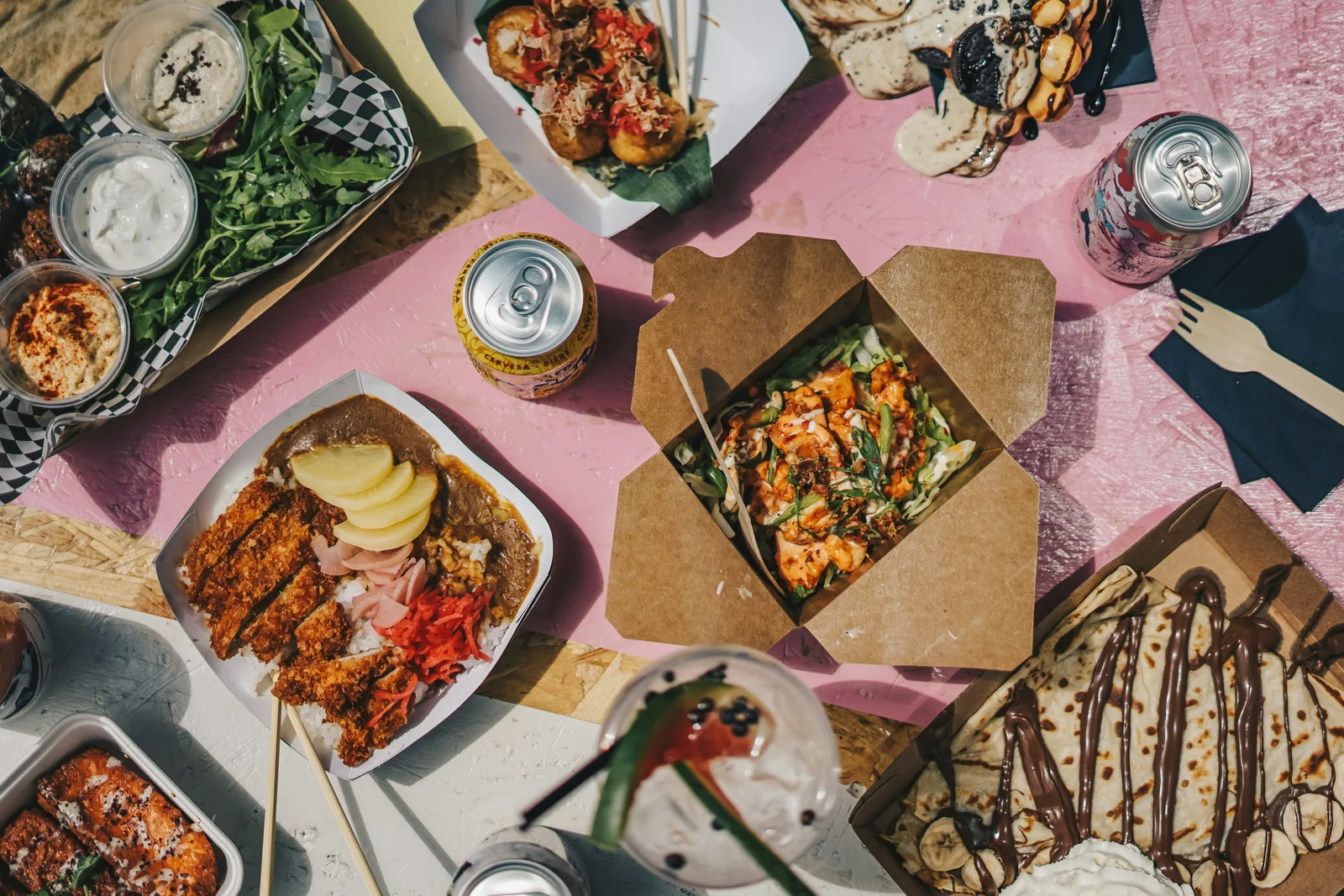 A shared table of street food, rice dishes and desserts.